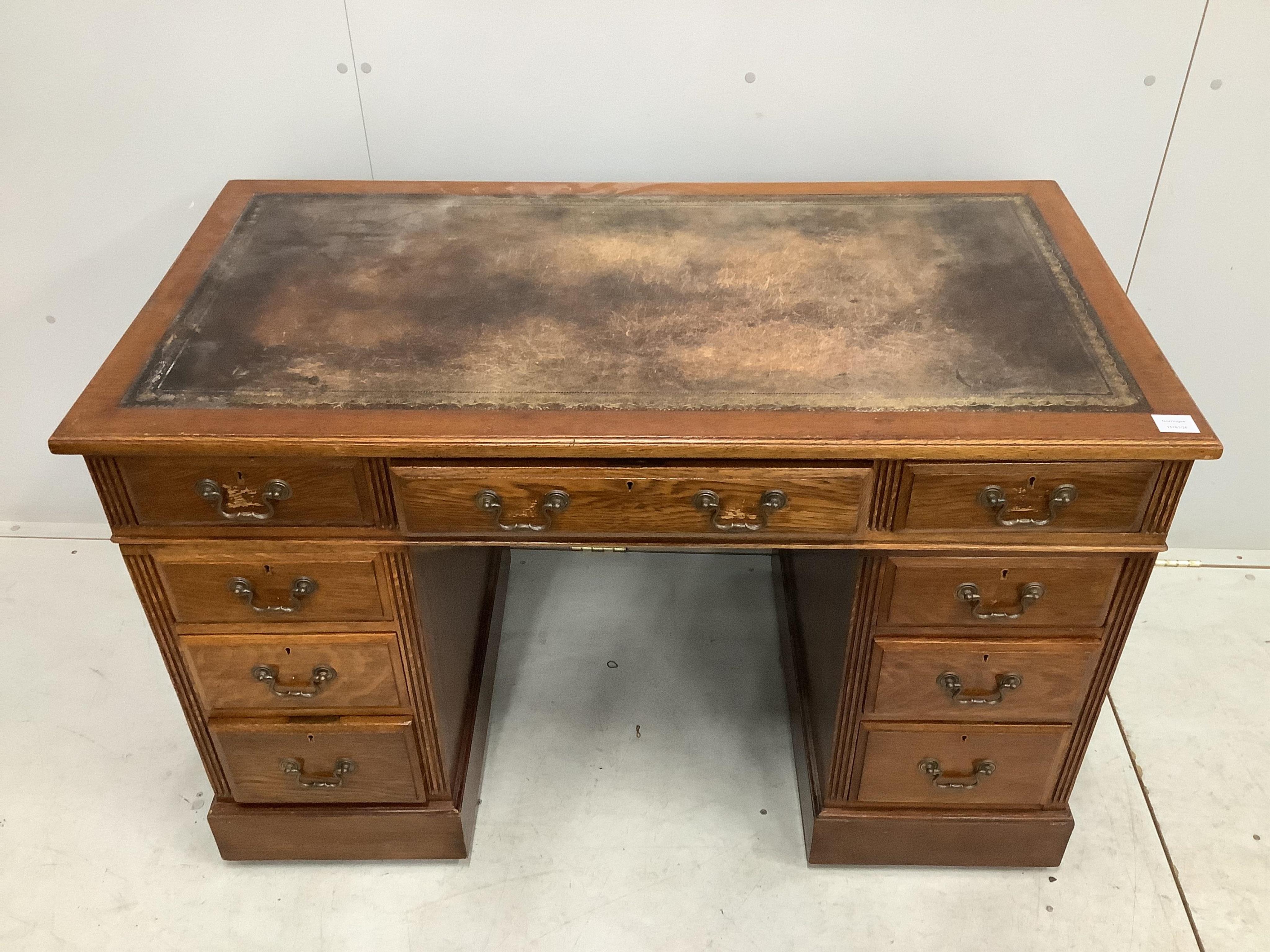 An early 20th century oak pedestal desk, fitted nine drawers, with a leather inset top, width 121cm, depth 64cm, height 78cm. Condition - fair